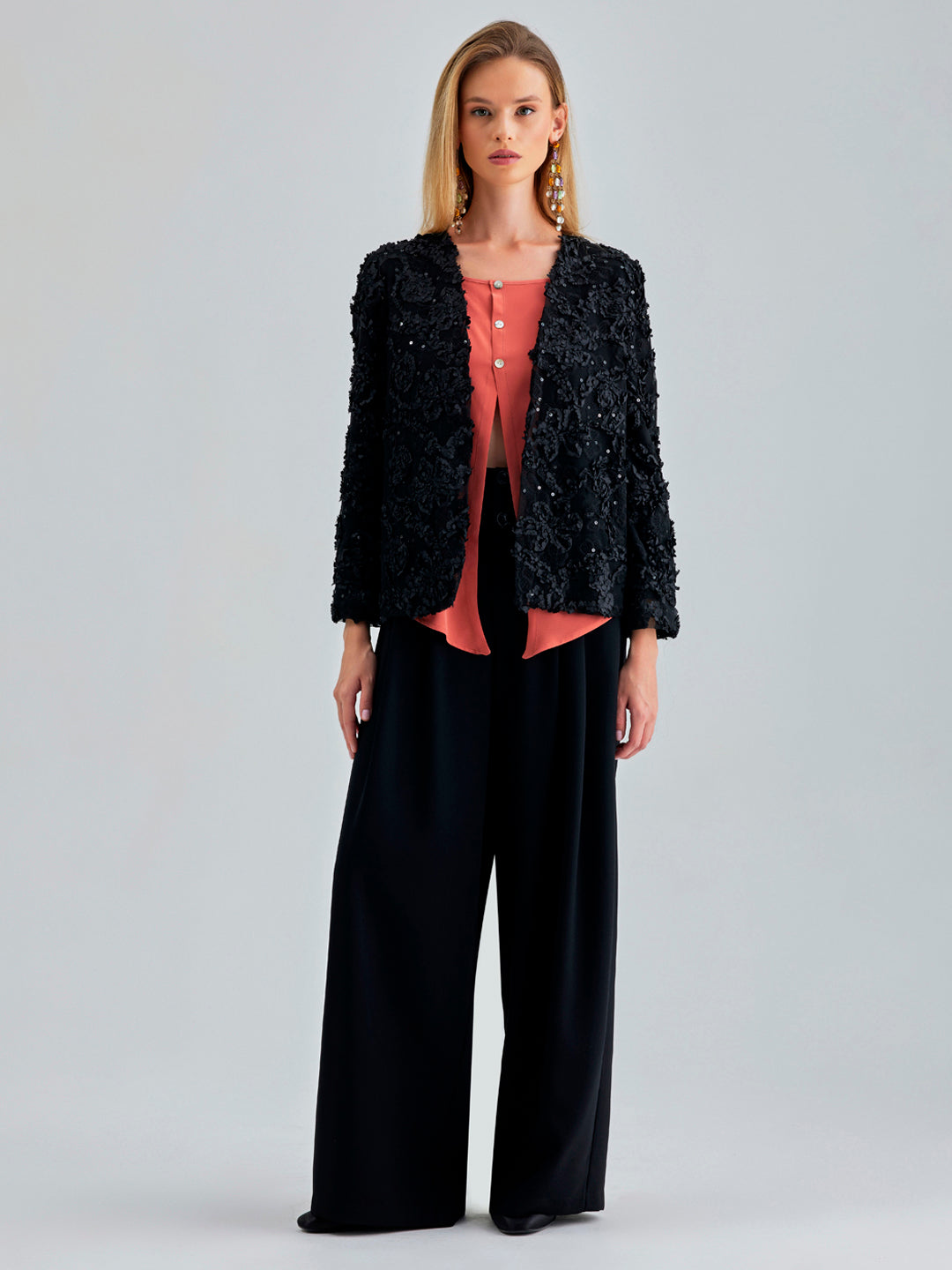 Elegant black jacket featuring subtle floral accents and chic sleeves