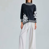 Elegant Leti Sweater featuring white floral accents along the sleeves and edges for a refined look