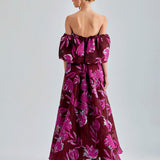 Red Zelene Gown featuring large floral patterns, low-cut shoulders, and a flowing, elegant design