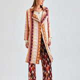 Playful and sophisticated coral jacket with distinctive fringed patterns